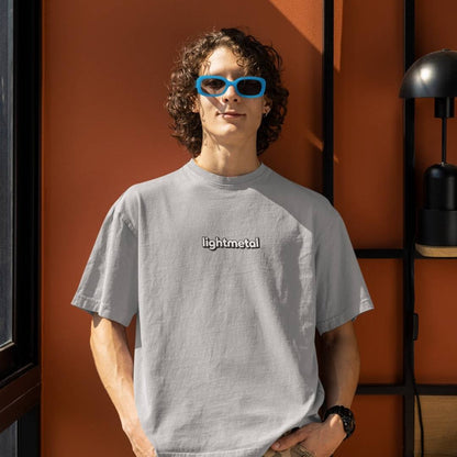 Stealth Gray - Person wearing a gray 'lightmetal' t-shirt with blue sunglasses against an orange wall.