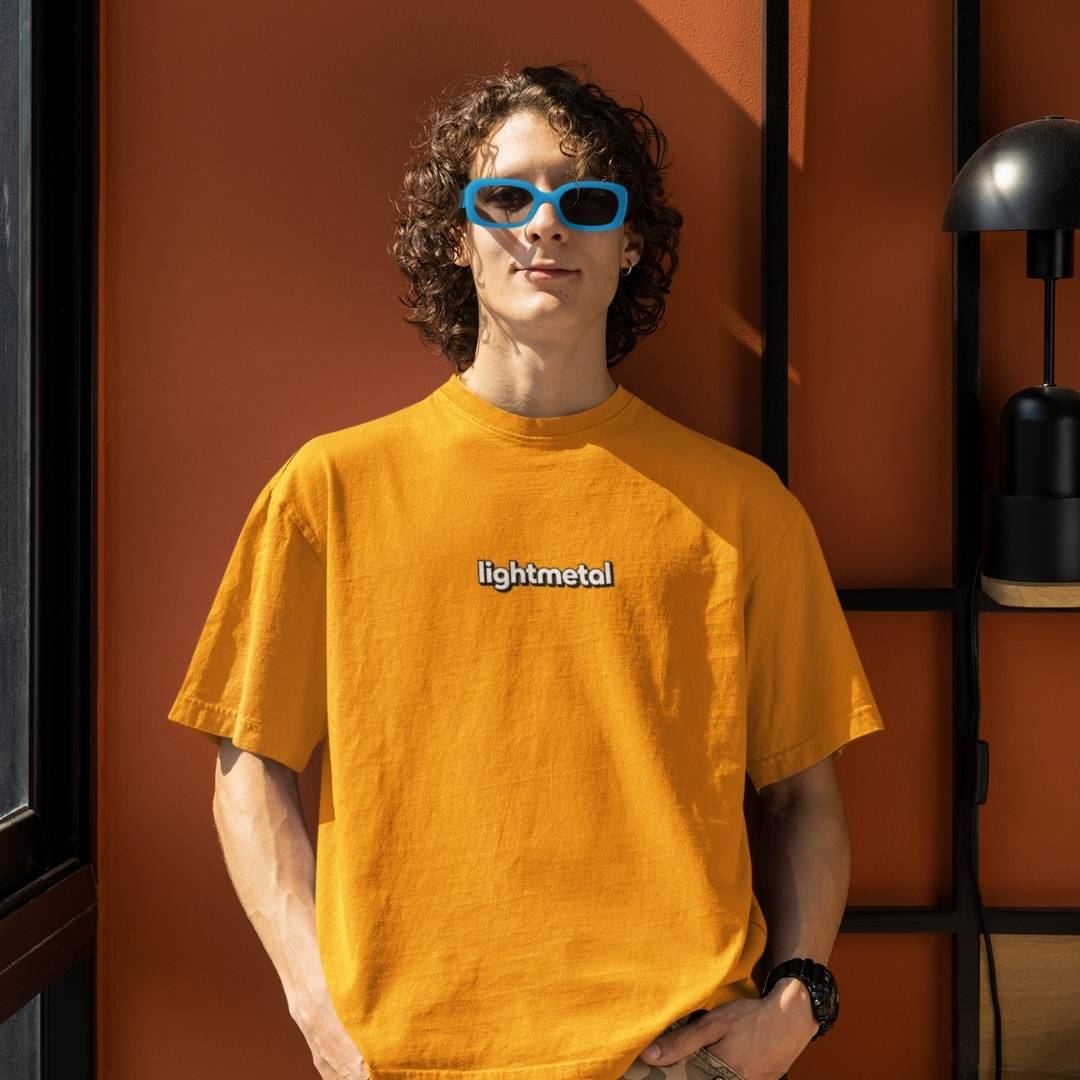 Wild Yellow - Person wearing a yellow 'lightmetal' t-shirt with sunglasses indoors.