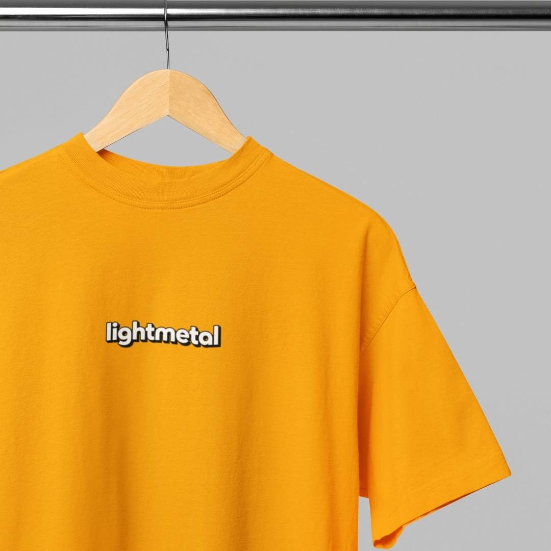Wild Yellow - t-shirt with 'lightmetal' logo on a hanger against a gray background