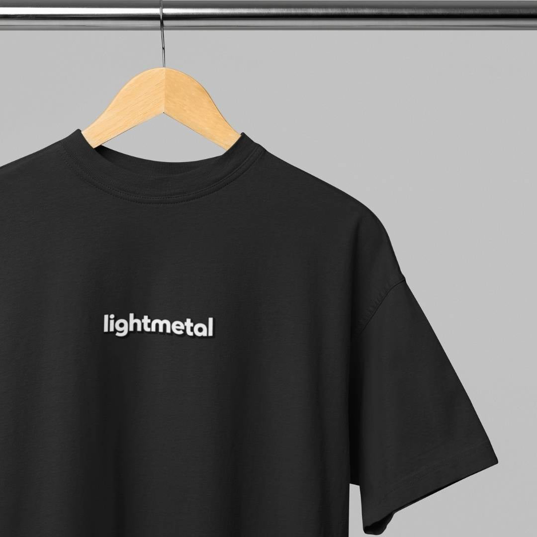 Honest Black - t-shirt with 'lightmetal' logo on a hanger against a gray background