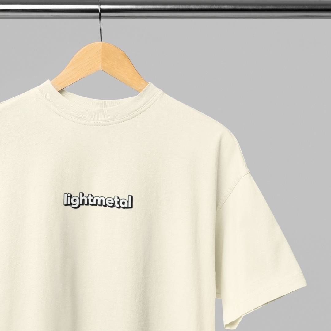 Corporate Beige - t-shirt with 'lightmetal' logo on a hanger against a gray background