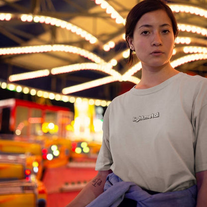 Stealth Gray - Person wearing a light-colored t-shirt with 'lightmetal' logo in an indoor setting with blurred lights and objects.