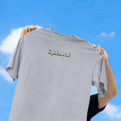 Stealth Gray - t-shirt with 'lightmetal' logo held against a blue sky