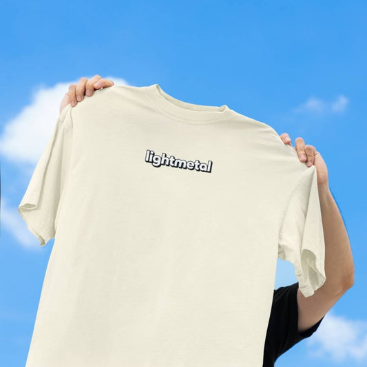 Corporate Beige - t-shirt with 'lightmetal' logo held against a blue sky